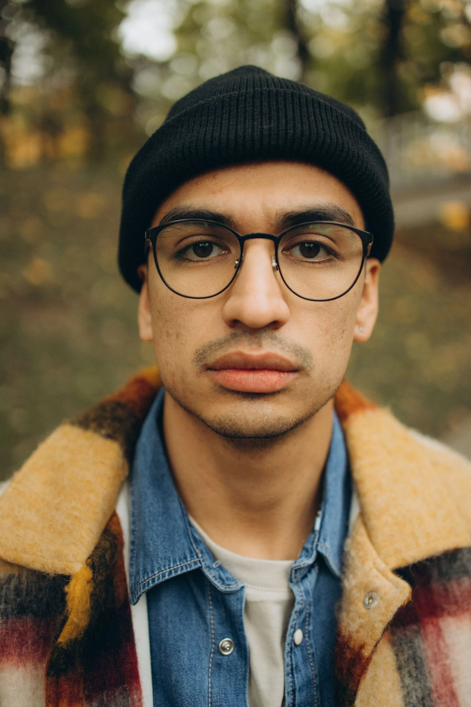 Homme portant une monture noire, en lumière naturelle.